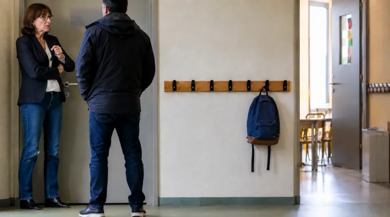 Directrice échangeant avec un parent dans un couloir d’école