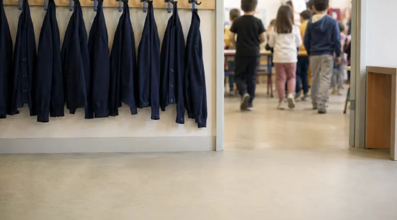 Tenues scolaires suspendues dans un couloir d’école